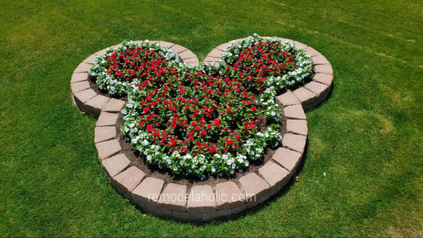 Diy Mickey Planter Bed With Landscaping Blocks And Red And White Flowers Remodelaholic