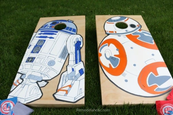 custom painted cornhole boards painted with Star Wars droids BB-8 and R2-D2, on the grass in a backyard
